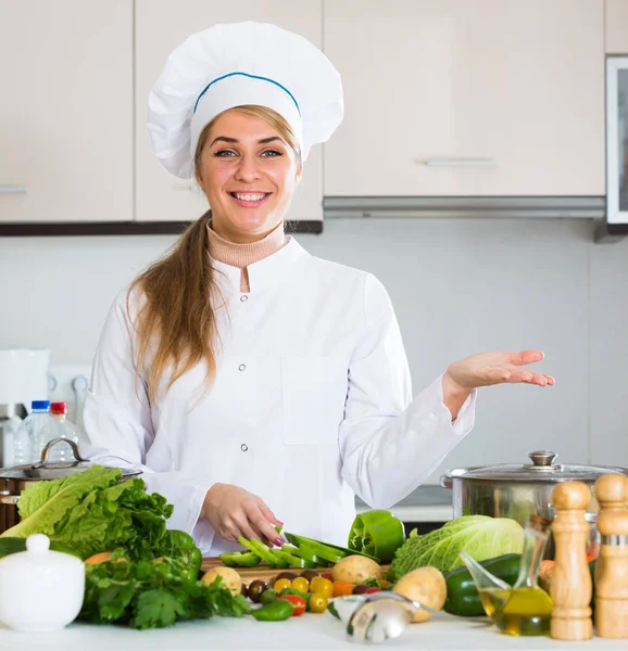 Profi-Koch mit Gemüse am Küchentisch — Stockfoto