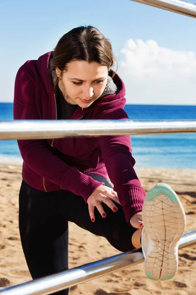 Mulher desportiva exercitando na praia do mar — Fotografia de Stock