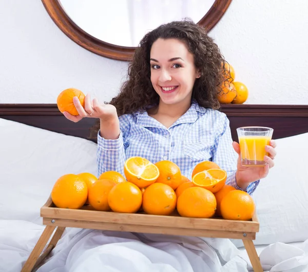 Chica positiva con naranjas maduras y vaso de jugo —  Fotos de Stock