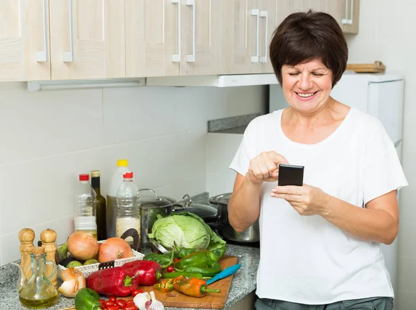 Senior vrouw op zoek telefoon — Stockfoto