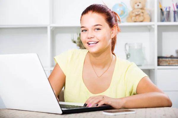 Kız öğrenci evde çalışırken dizüstü bilgisayarda daktilo kullanıyor. — Stok fotoğraf