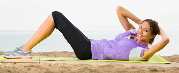 Entraînement féminin sur la plage le matin et souriant — Photo