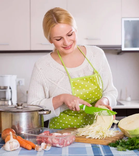 Dona de casa cozinhar com carne e repolho — Fotografia de Stock