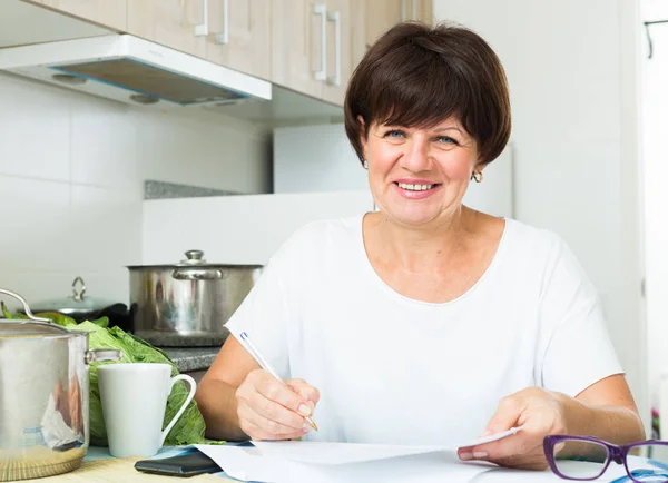 Mujer alegre pagando facturas — Foto de Stock