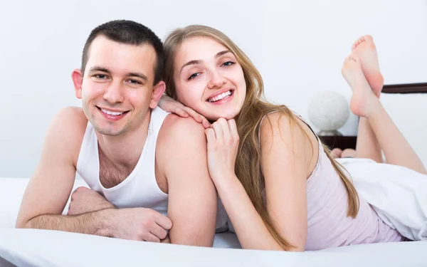 Young loving couple lounging in be — Stock Photo, Image