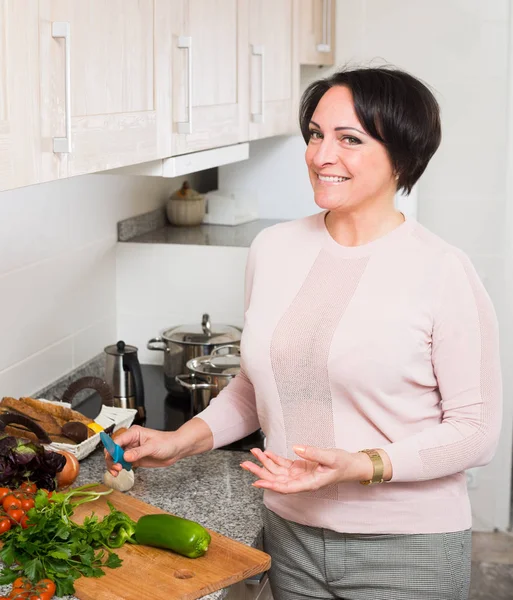 Positieve huisvrouw koken groenten thuis — Stockfoto