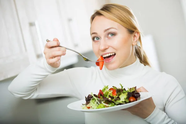 Счастливая девушка с овощным салатом на кухне — стоковое фото