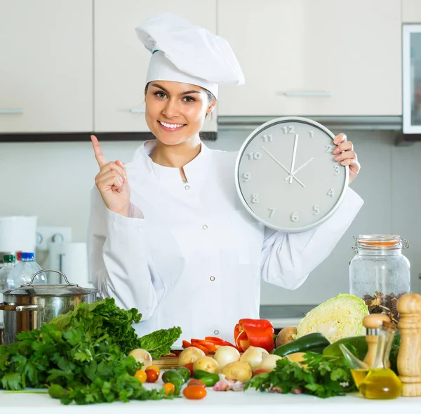 Kobieta z zegarem w kuchni — Zdjęcie stockowe