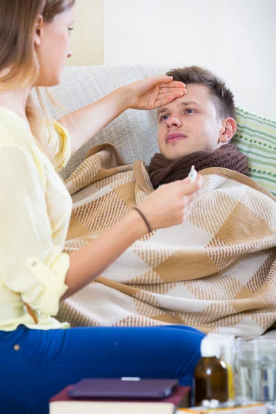 Vrouw raakt man voorhoofd om koorts te controleren — Stockfoto