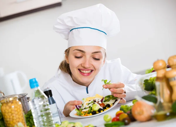 Positive chef decorating salad with parsley in kitchen — Stock Photo, Image