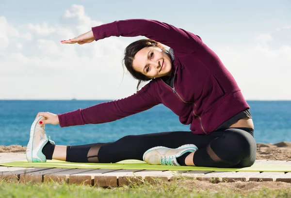 Girl exercising on exercise mat outdoor — Stock Photo, Image