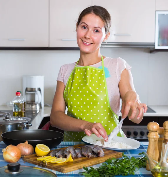 Housewife frying fish at kitche — Stock Photo, Image