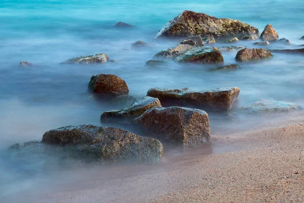 Zee rotsen in nevel bij zonsondergang — Stockfoto