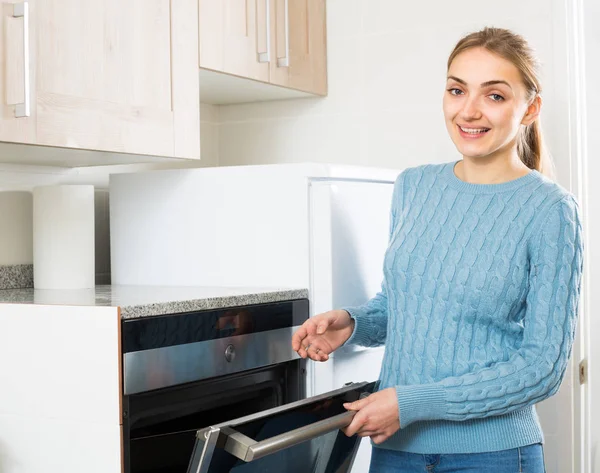 Meisje bij keuken oven bij hom — Stockfoto