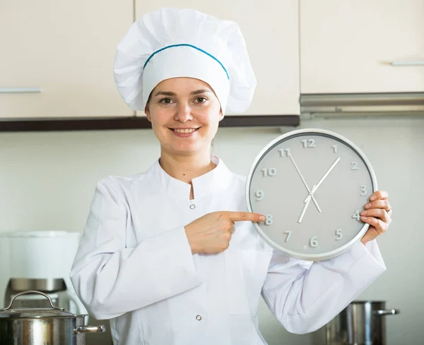 Cheerful woman in cook uniform with big clock — Stok fotoğraf