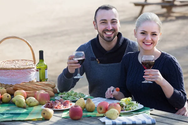 Koppel wijn drinken en praten op de picknick — Stockfoto