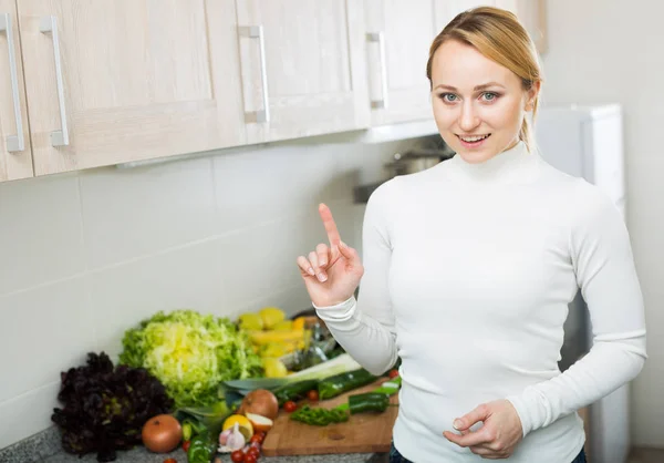 Mulher feliz com variedade de legumes na cozinha — Fotografia de Stock