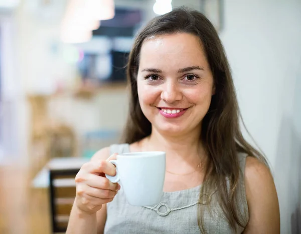 Menina morena bonita bebendo chá no café — Fotografia de Stock