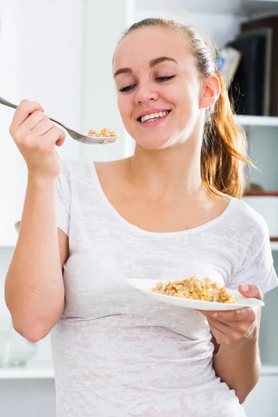 Ritratto di giovane donna che mangia poltiglia in cucina — Foto Stock