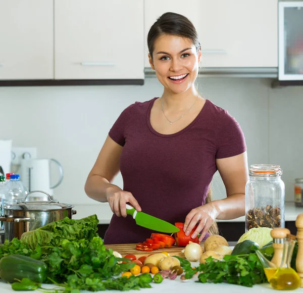 Žena se zeleninou u kuchyňského stolu — Stock fotografie