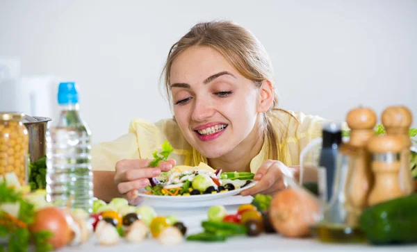 Счастливая молодая женщина с тарелкой овощного салата — стоковое фото