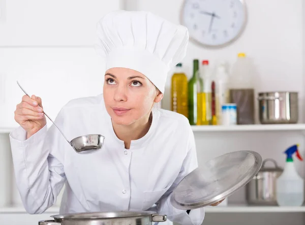 Glimlachende Vrouwelijke Kok Controleren Smaak Van Voedsel Tijdens Het Bereiden — Stockfoto