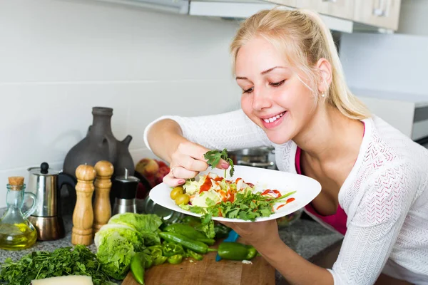 明るい笑顔ブロンドの女の子家のキッチンで野菜から健康的なサラダを準備 — ストック写真