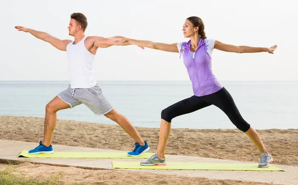 Pareja Joven Que Hace Ejercicio Yoga Posa Parada Playa Soleada —  Fotos de Stock