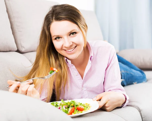 笑顔の女性は自宅で喜びと新鮮な緑のサラダを味わう — ストック写真