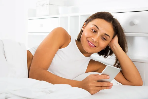 Jonge Glimlachende Blanke Vrouw Met Behulp Van Haar Telefoon Bed — Stockfoto