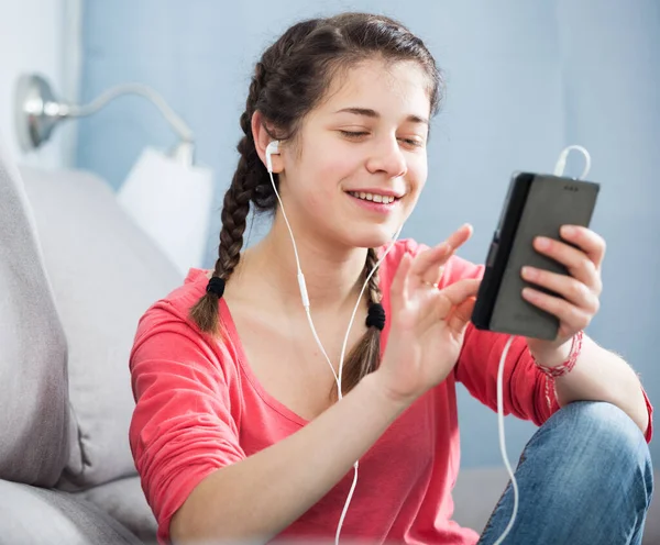 Uśmiechnięta Dziewczyna Smsuje Telefonem Słucha Muzyki Domu — Zdjęcie stockowe