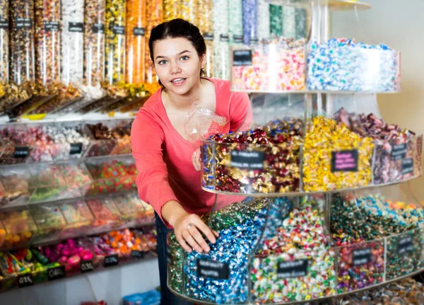 Cheerful Young Woman Posing Photographer Picking Different Candies Scoop Cellophane —  Fotos de Stock