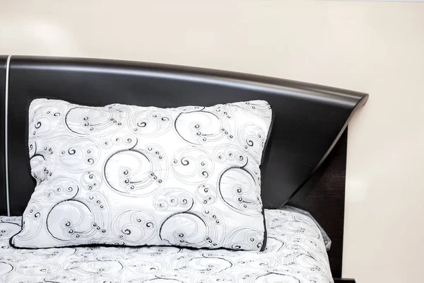 Abanoz yatak odası iç güçlü bir yatak üzerinde siyah işlemeli desenleri ile beyaz yastık