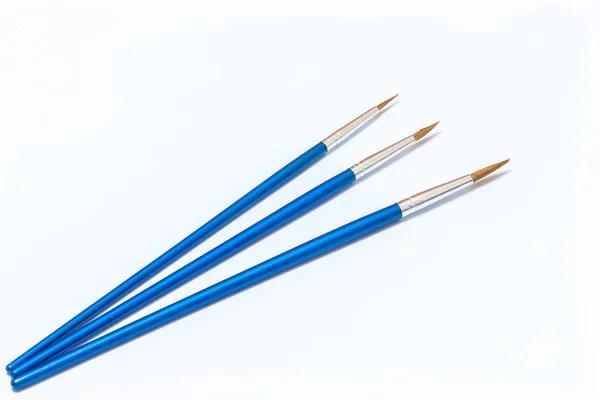 Three blue paint brushes on a white background. Isolated — Stock Photo, Image