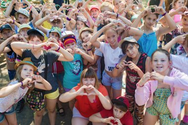 Çocukların büyük bir grup eller kalp simgesini gösterir. Çocuk Kampı 