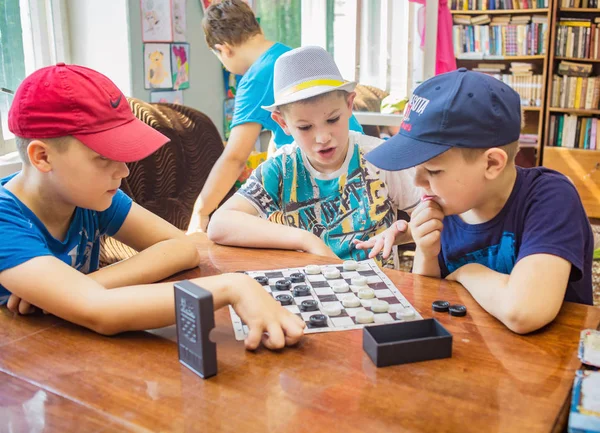 男孩玩跳棋棋盘游戏 儿童营 Berezka 俄罗斯 雅罗斯拉夫尔地区16 2016 图库图片