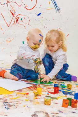 Oğlan ve kız çiziyor.