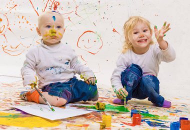 Oğlan ve kız çiziyor.