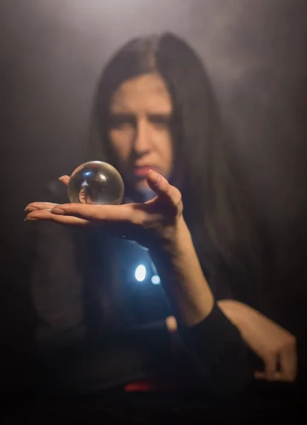 The woman holds a magic sphere