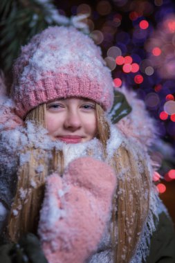 Karla kaplı pembe şapkalı bir kızın portresi.