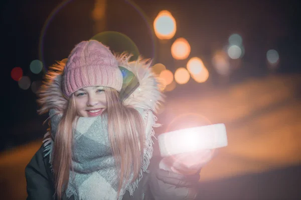 冬天散步时 一个快乐的女孩手里拿着一个礼品盒 — 图库照片