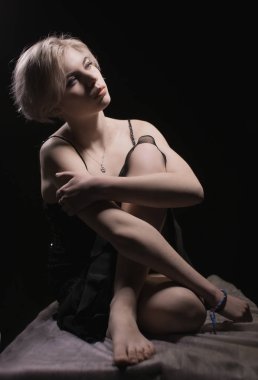 Beautiful girl sitting in black dress