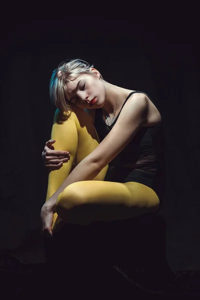 Bella Ragazza Seduta Sfondo Nero Collant Giallo — Foto Stock