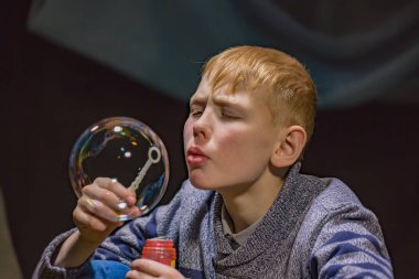 Çocuk sabun köpüğünü şişiriyor.