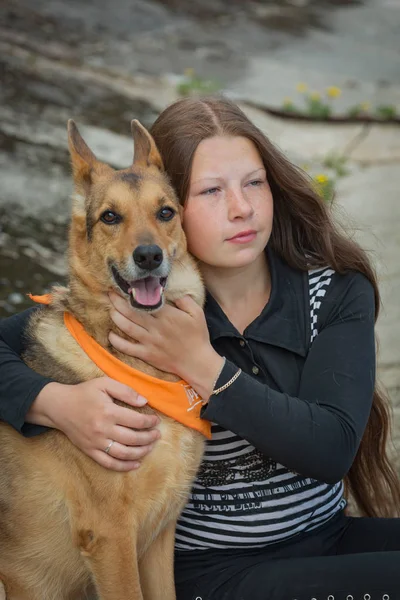 海岸に座っている犬を持つ女の子 — ストック写真