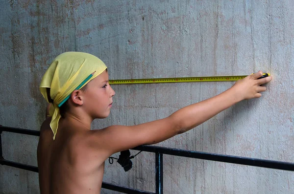 Adolescente medindo uma parede — Fotografia de Stock