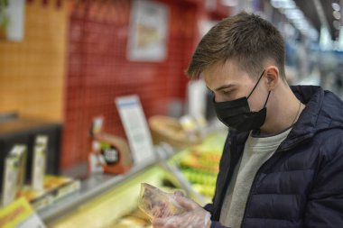 Maskeli bir Coronavirus süpermarketi alışveriş yapıyor.