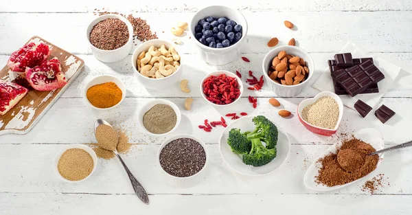 Super voedingsmiddelen op een witte houten achtergrond. — Stockfoto