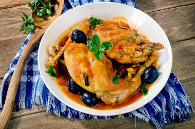 Demlenmiş tavşan bacağı zeytin ve otlar ile. 