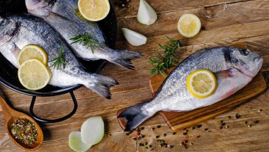 Ahşap masa üzerinde otlar ile taze çiğ balık